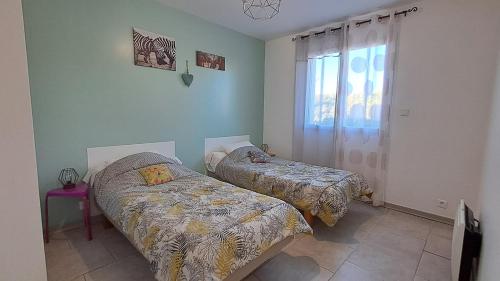 une chambre avec deux lits et une fenêtre dans l'établissement Gîte soleil ardéchois Manon, à Sampzon