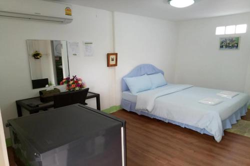a bedroom with a bed and a flat screen tv at Coconut Home Resort in Damnoen Saduak