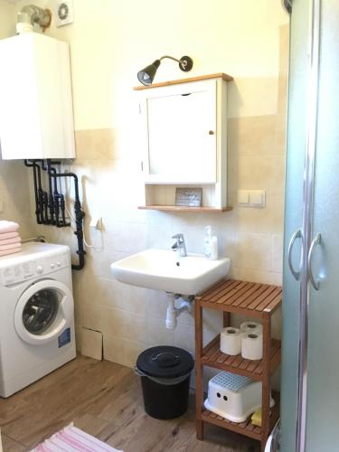 a bathroom with a sink and a washing machine at Fajne Domki in Władysławowo-Chłapowo
