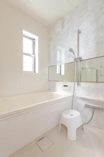 a white bathroom with a tub and a toilet at 三浦海岸 SeaLightVilla B棟 in Miura