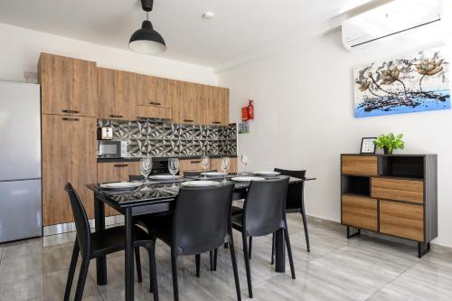 uma sala de jantar com uma mesa preta e cadeiras em F9 Modern and Bright Apartment in Malta em Msida