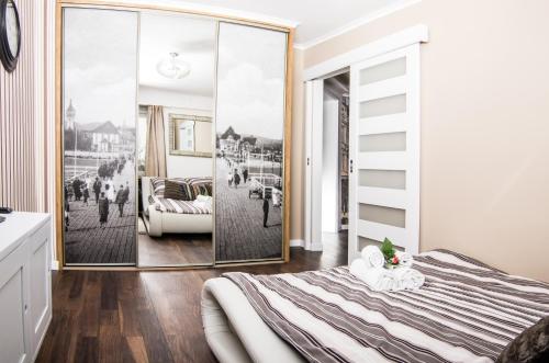 ソポトにあるKlimatyczny apartament Salamandra w Sopocieのベッドルーム(ベッド1台、大きな鏡付)