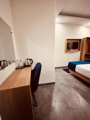 a hotel room with a bed and a table and a bed gmaxwell gmaxwell gmaxwell gmaxwell at Hotel The Rise At Delhi Airport in New Delhi
