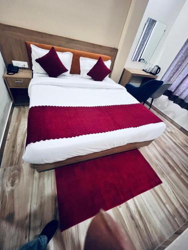 a bedroom with a large bed with red pillows at Hotel The Rise At Delhi Airport in New Delhi
