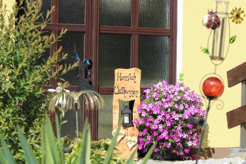 a sign in front of a window with flowers at Ferienwohnung Werner in Warmensteinach