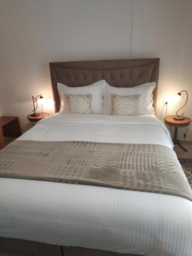a bedroom with a large white bed with two tables at Pepi Cozy in Alexandroupoli