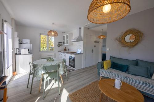 un salon et une cuisine avec un canapé et une table dans l'établissement Cabane 18 - A 10min de la Dune du Pilat, à La Teste-de-Buch