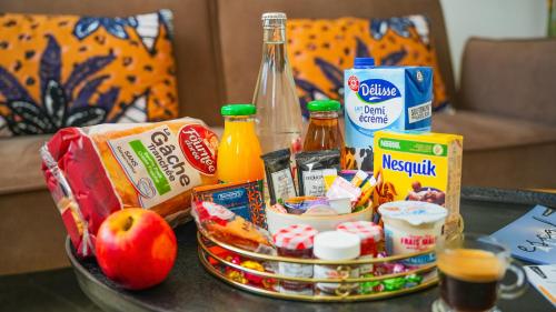 a table topped with a basket of food and drinks at KoonTy - Chambres et Appartements à Landerneau in Landerneau