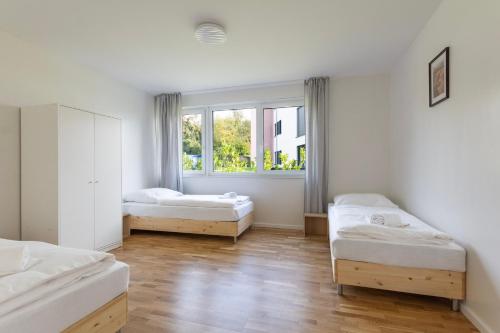a room with three beds and a window at T&K Apartments - BERGISCH GLADBACH - 7 Comfortable Apartments - 20 min to Fair Messe Cologne in Cologne