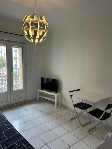 un salon avec une télévision, une table et des chaises dans l'établissement Foch 3-Studio-Beziers center -wifi -tv connected, à Béziers