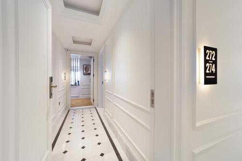 a hallway with white walls and a black and white tile floor at Mula Hotel in Istanbul