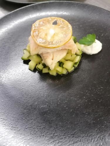 a plate with a piece of food on top of vegetables at Wellnesshotel Parkschlössl zu Thyrnau Ihr adults only SPA Resort in Thyrnau