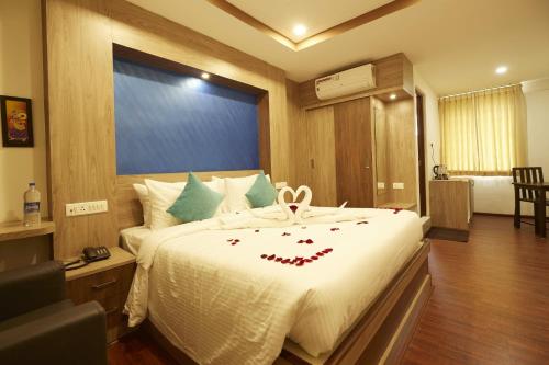 a bedroom with a large bed with red flowers on it at Hotel Ramtel inn in Madurai