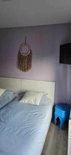 a bedroom with a bed and a wreath on the wall at Chambres d'hôtes à 5min de Pairi Daiza et proche du SHAPE-OTAN in Lens
