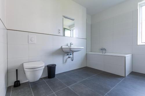 a white bathroom with a toilet and a sink at T&K Apartments - BERGISCH GLADBACH - 7 Comfortable Apartments - 20 min to Fair Messe Cologne in Cologne