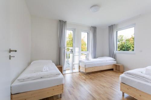 a room with two beds and a window at T&K Apartments - BERGISCH GLADBACH - 7 Comfortable Apartments - 20 min to Fair Messe Cologne in Cologne
