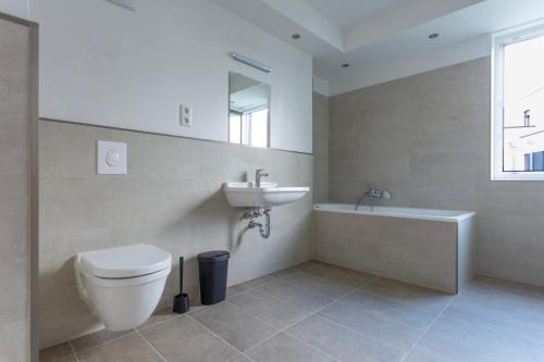 a bathroom with a toilet and a sink and a tub at T&K Apartments - BERGISCH GLADBACH - 7 Comfortable Apartments - 20 min to Fair Messe Cologne in Cologne