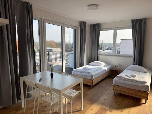 a room with two beds and a table with chairs at T&K Apartments - BERGISCH GLADBACH - 7 Comfortable Apartments - 20 min to Fair Messe Cologne in Cologne