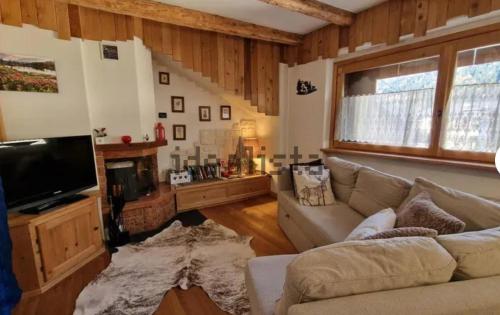 a living room with a couch and a tv at Ciaseles a due passi da Cortina d'Ampezzo in San Vito di Cadore
