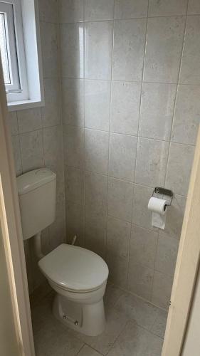 a bathroom with a toilet and a roll of toilet paper at Thea's Home in Sint Annaland
