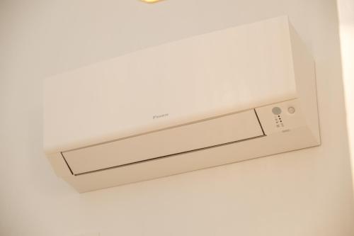 a white microwave oven hanging on a wall at CALMAPIANTA home for green lovers in Putignano