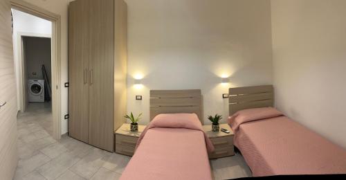 2 łóżka w sypialni z różową pościelą w obiekcie Kero House w mieście Alghero