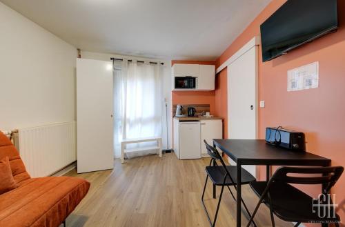 un salon avec une table et un canapé dans l'établissement Venus - Proche A10 - 2V - Parking, à Saint-Pierre-des-Corps