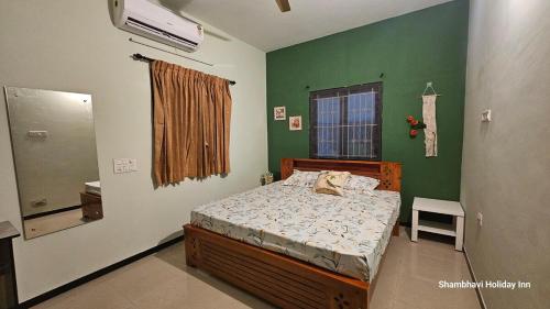 コインバトールにあるSHI's Shenba 3BHk Villa Near Ganga Hospital Coimbatoreのベッドと緑の壁のある寝室