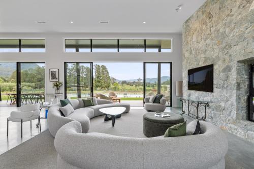 a living room with a couch and a fireplace at Chris' - Designer Masterpiece In Kangaroo Valley in Kangaroo Valley