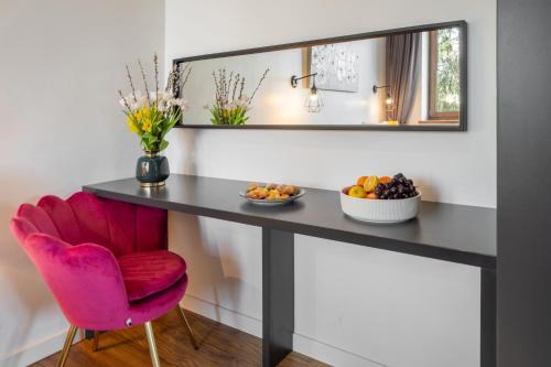 a table with a pink chair and a mirror at WILLA JAROSTA & SPA, AC -free parking in Zakopane