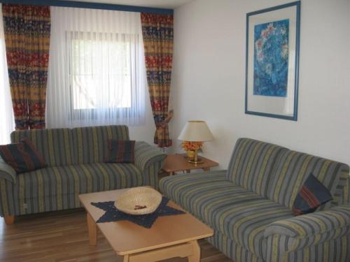 un salon avec deux canapés et une table dans l'établissement Ferienhaus Nr 127, Kategorie Komfort L, Feriendorf Hochbergle, Allgäu, à Karlsebene