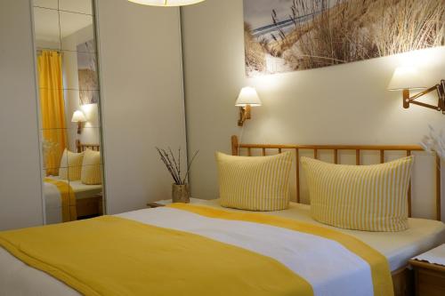クリュツにあるPalms Ferienhausのベッドルーム1室(黄色と白の枕付きのベッド1台付)