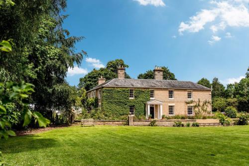 an old stone house with a large yard at Hockham Grange in Hockham
