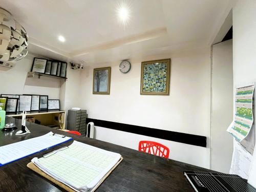 an office with a table and a clock on the wall at BGC Suites Uptown in Makati
