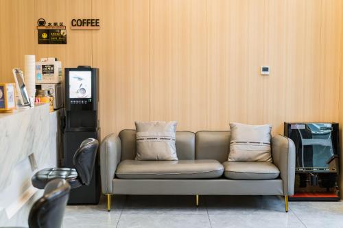 a couch with two pillows sitting in a room at Dequan Hotel Guangqumen Outer Branch in Beijing