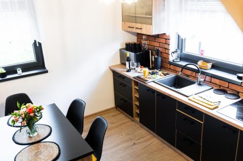 a kitchen with a table and chairs and a sink at Beskid Loft House - domki w górach in Sól