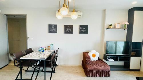 een eetkamer met een tafel, stoelen en een televisie bij The base Condo 2 bedroom 1 bathroom in Pattaya
