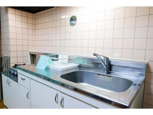 さいたま市にあるHOTEL Nishikawaguchi Weekly - Vacation STAY 43479vのタイル張りの壁、シンク付きのキッチン