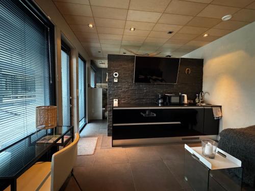 a living room with a flat screen tv and a couch at Luxus Guest Suite & SAUNA Finnish design house in Espoo