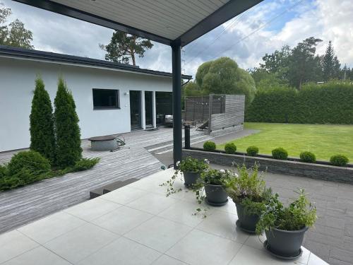 a patio with potted plants in a yard at Luxus Guest Suite & SAUNA Finnish design house in Espoo