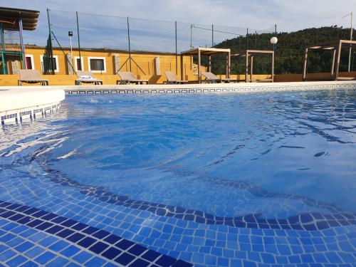 a large swimming pool with blue water at Complejo Rural Las Lomas de Biar in Biar