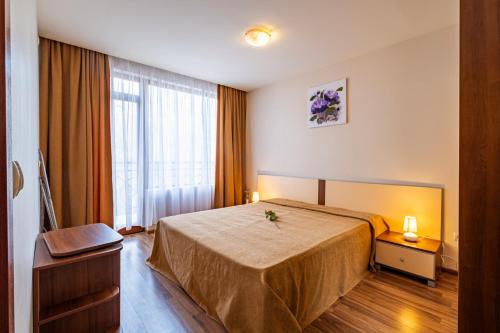 una habitación de hotel con una cama y una ventana en Primrose Apartment with Free Parking, en Varna