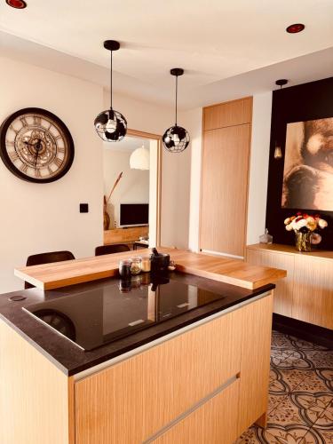 une cuisine avec un évier et une horloge murale dans l'établissement Le Longo Maï ,2 chambres, parking gratuit, à La Garde