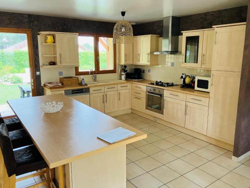 une cuisine avec des armoires en bois et un comptoir dans l'établissement Havre de paix proche CNPE Bugey, à Hières-sur-Amby