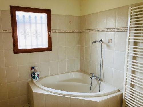 une baignoire dans une salle de bain avec une fenêtre dans l'établissement Havre de paix proche CNPE Bugey, à Hières-sur-Amby