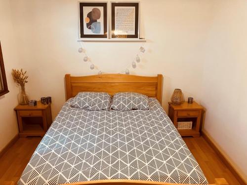 une chambre avec un lit et deux tables de nuit dans l'établissement Havre de paix proche CNPE Bugey, à Hières-sur-Amby