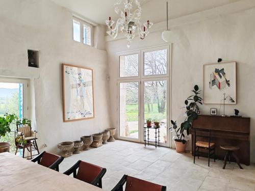 Cette grande chambre comprend une table, des chaises et un lustre. dans l'établissement Charme et Confort - Maison Rénovée avec Piscine -, à Condillac