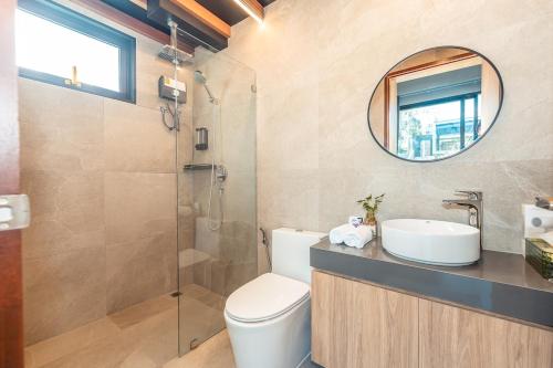 a bathroom with a toilet and a sink and a mirror at Merbrisa Rayong poolvilla-Ao khai beachfront in Mae Pim