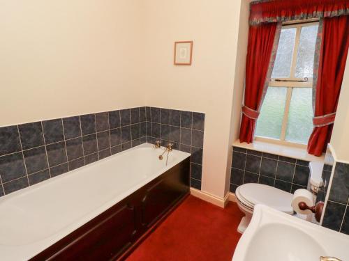 ein Badezimmer mit Badewanne und Toilette in der Unterkunft Fern Cottage in Wooler