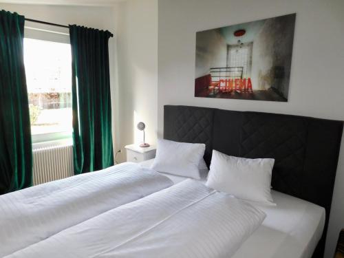 a bedroom with a large white bed with a window at Pension Rohrer am Murradweg - Ehrenhausen an der Weinstrasse in Ehrenhausen